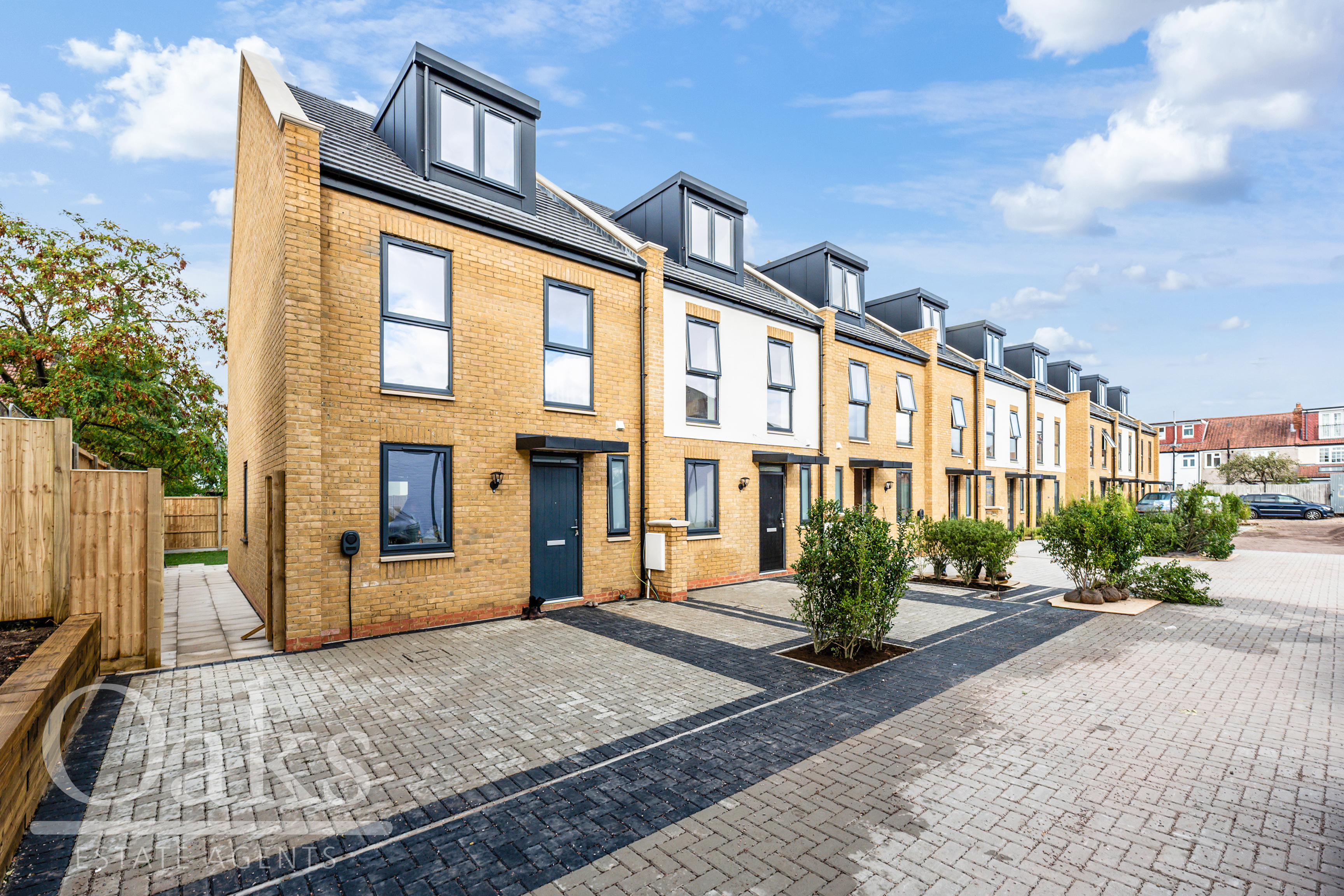 Modern terraced homes with brick facade and private driveways at Byards Croft residential development, Dion Homes.