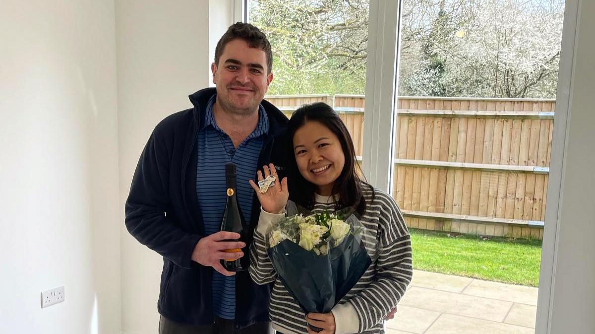 Couple with flowers in their new Dion Homes kitchen at Oakley Gardens