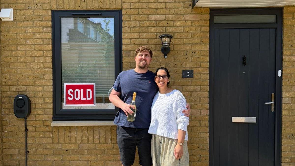 Couple standing outside their newly purchased home at Blossom Way after completion.